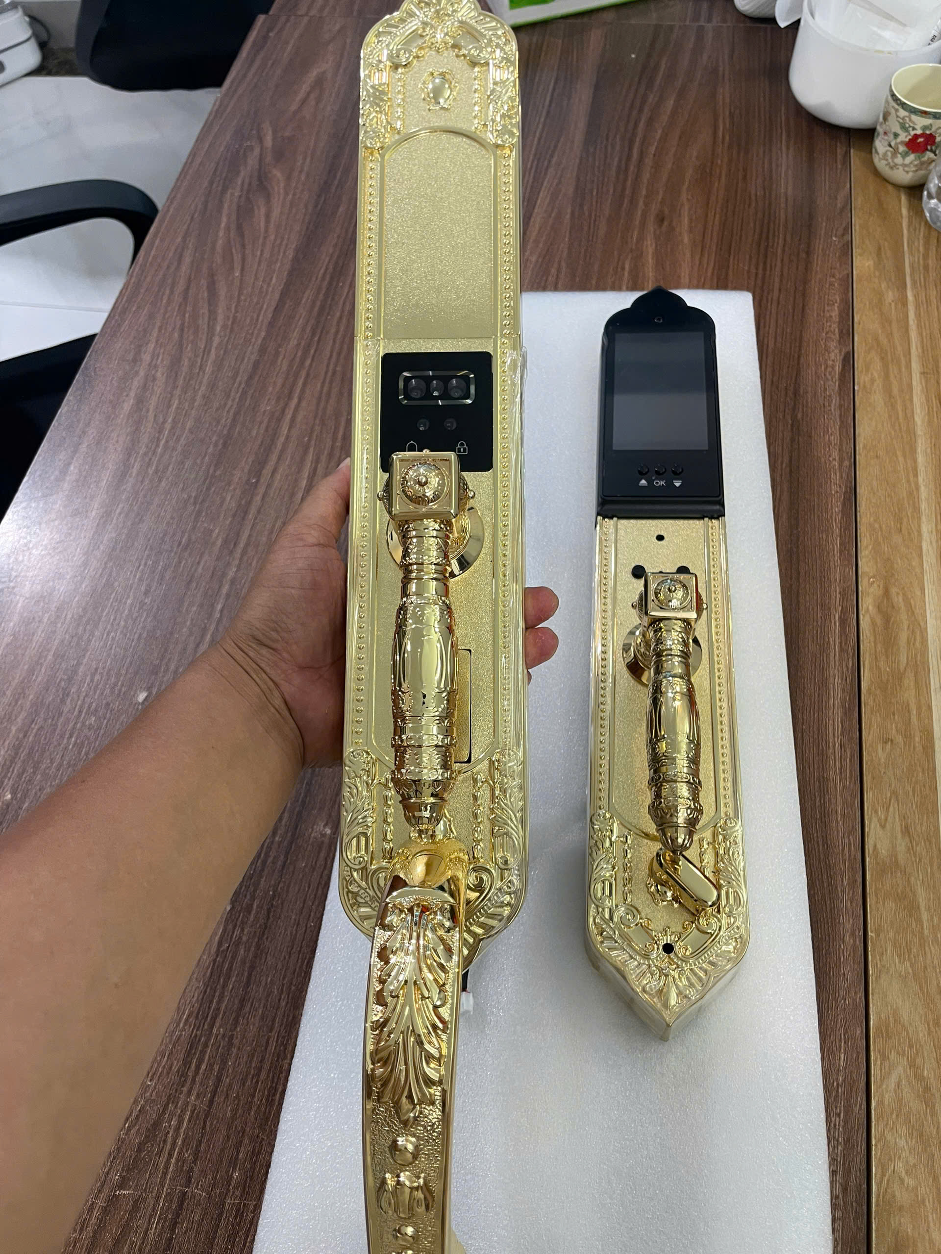 Trên tay bộ khóa đại sảnh thông minh thiêt kế tân cổ điển, mạ màu vàng 24K, của hãng Kawa KDS66G-Face